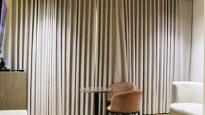 Una habitación con un ventanal grande, una mesa redonda y dos sillas.