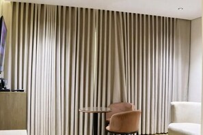 A room with a large window, a round table, and two chairs. - Nasamat Silver Hotel (Madinah)