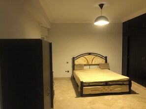 Una camera da letto con un letto, un armadio e una lampada a soffitto.