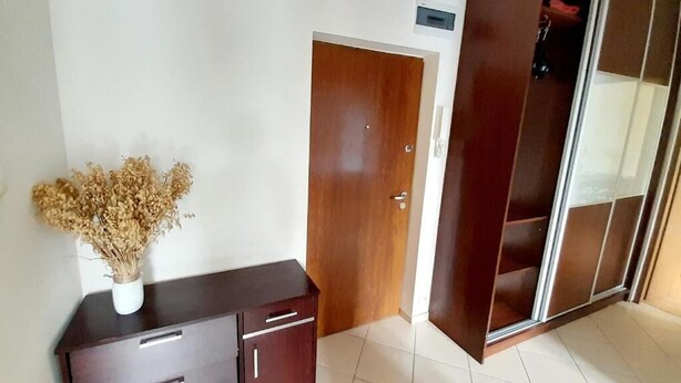 A room with a wooden wardrobe, a small cabinet, and a vase with dried flowers. - W Sercu Olsztyna z Widokiem na Historię (Olsztyn)