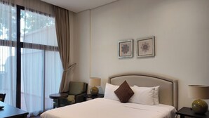 A hotel room with a large bed, bedside tables, a desk, and a chair. - Anantara Palm Jumeirah Luxury 1BR Sea View (Dubai)