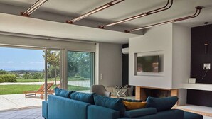 Un saló modern amb un sofà modular, una llar de foc i una televisió penjada a la paret.