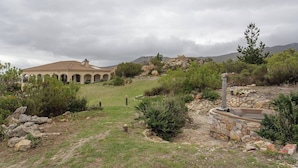 A building with a dome roof and arches, surrounded by a landscaped garden with a stone pathway and a small pool. - Barton Hammerkop Villa nr Hermanus - Hottub & Pool (Bot River)