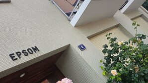 A modern building with a sign reading 'EPSOM' and a glass entrance. - Modern and functional apartment near the beach and downtown (Paris)