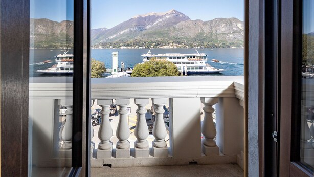 A balcony with a view of a lake, boats, and mountains. - Charming Bellagio Manzoni in the heart of Bellagio with beautiful lake view (Bellagio)