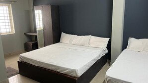 A bedroom with a large bed, a wardrobe, and a window. - Mysuru Dine  (Mysore)