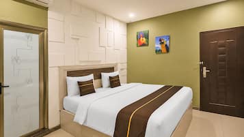 Habitación de hotel con una cama, una puerta y una pared decorada con obras de arte.