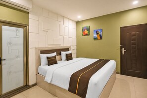 A hotel room with a bed, a door, and a wall with artwork. - Collection O Near Harbour Bay Mall formerly X Ten Guest House (Batam)