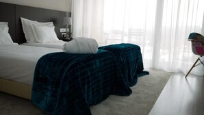 Ein Hotelzimmer mit Bett, Nachttisch, Lampe und Stuhl.