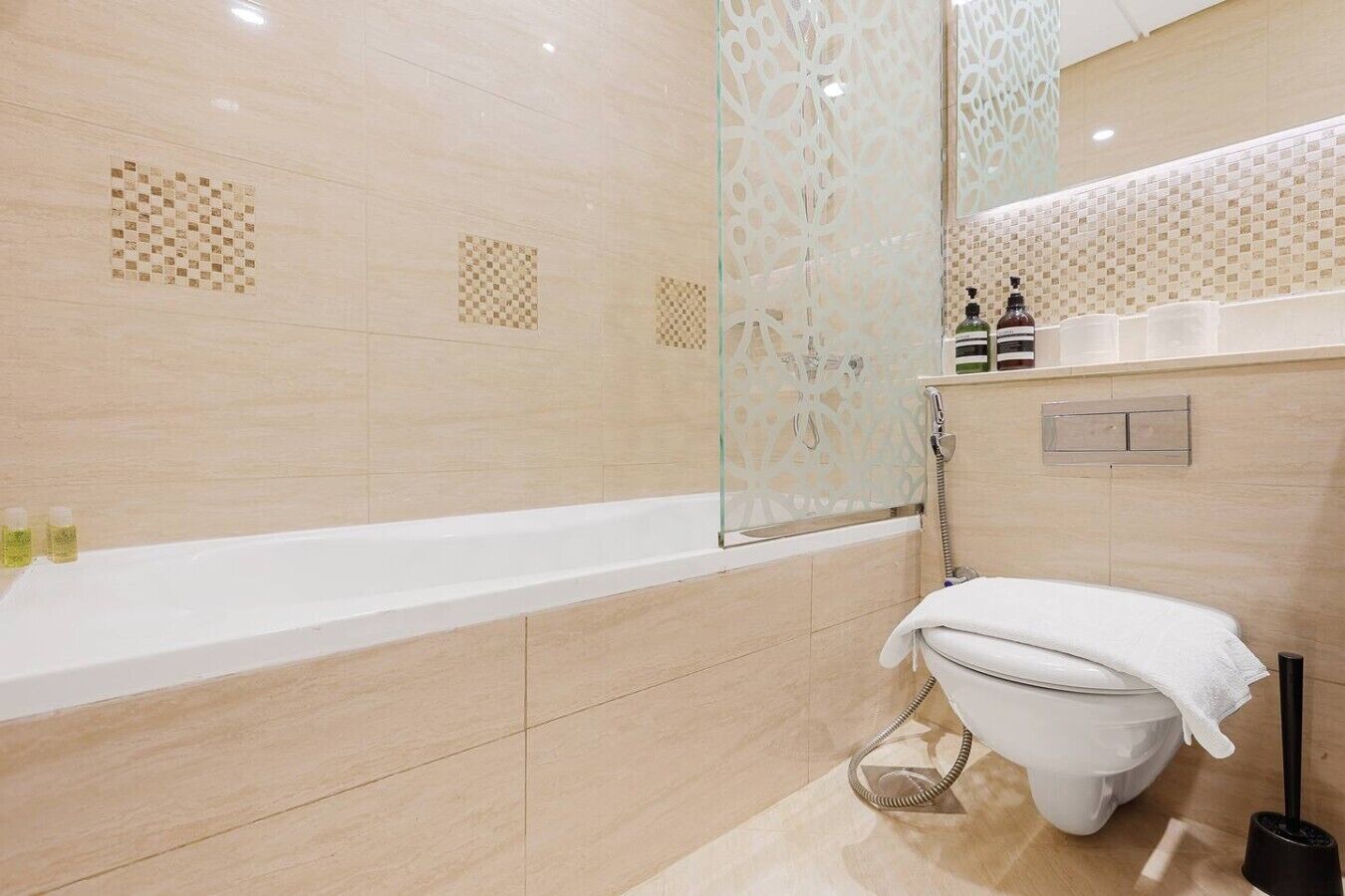 Een badkamer met een bad, toilet en douche.