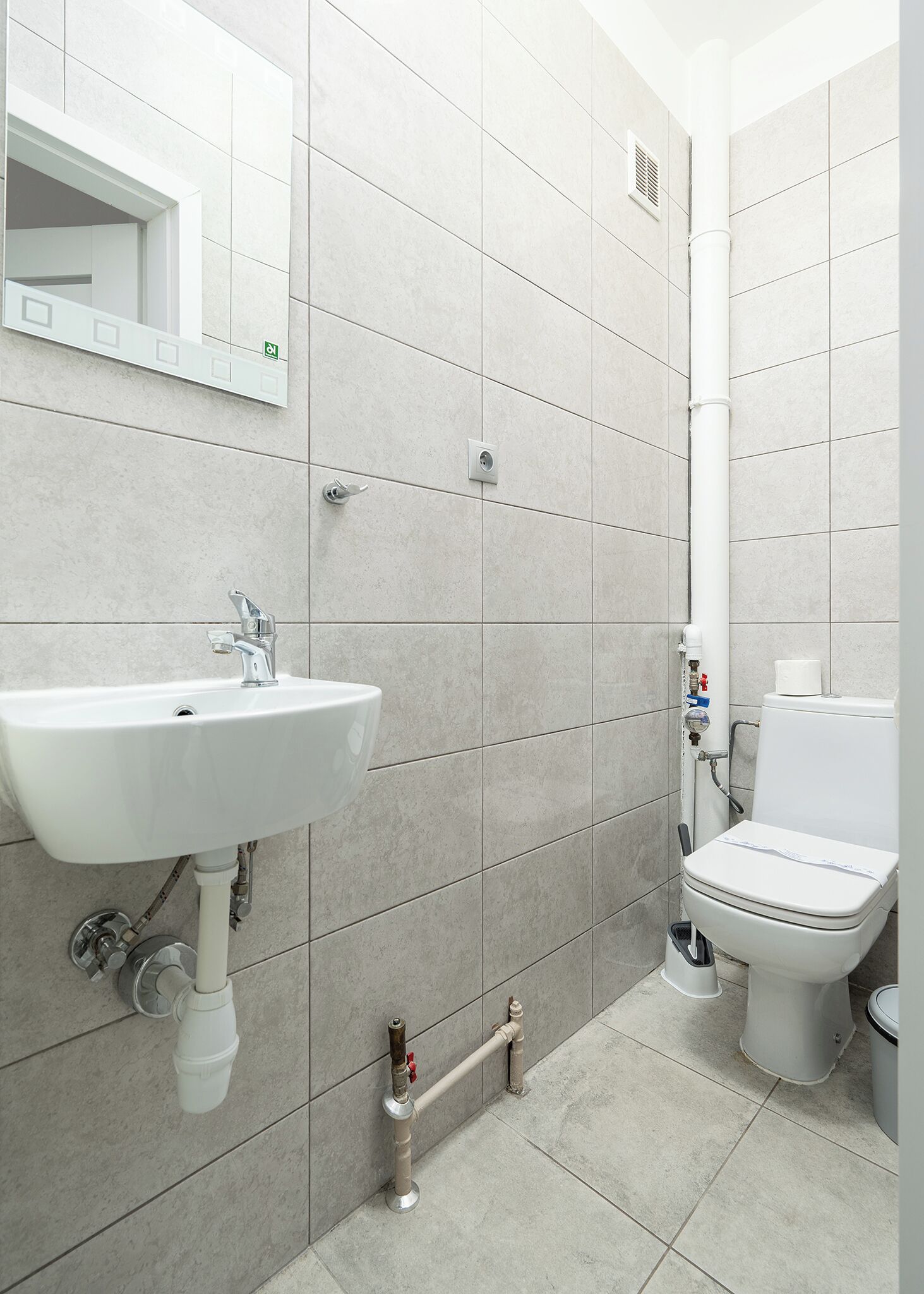 A bathroom with a sink, toilet, and shower area.