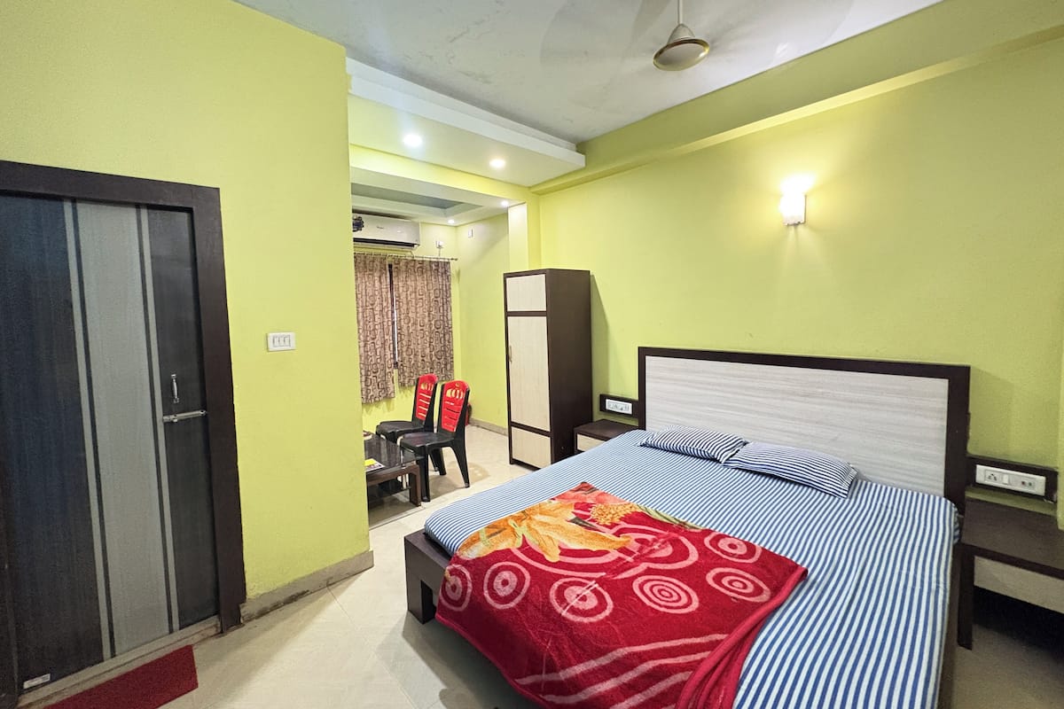 A bedroom with a bed, a wardrobe, a desk, and a chair.