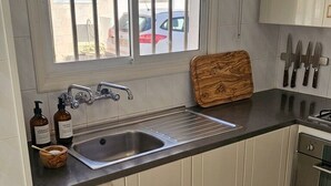 A kitchen with a window, stainless steel sink, cabinets, and a countertop. - Protaras 2 bedroom house (Paralimni)