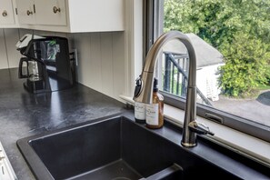 A kitchen with a stainless steel sink, a coffee maker, and two bottles of soap on the counter. - 2-bedroom apartment in gorgeous Ronks with cool AC (Ronks)