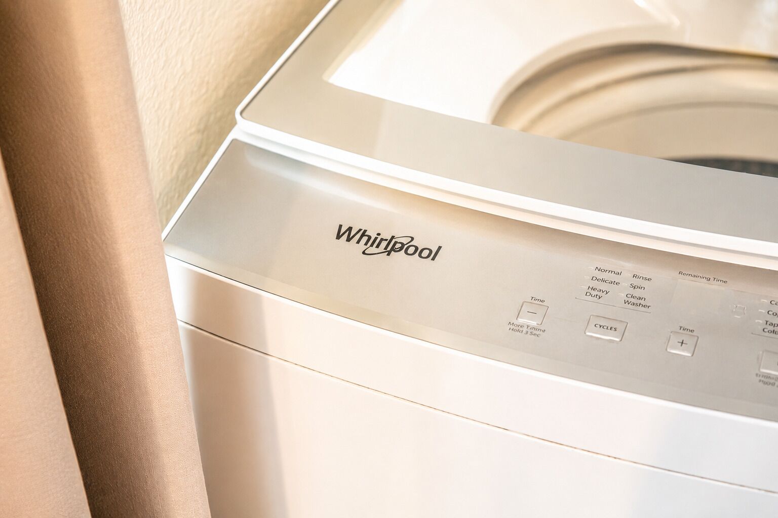 Vue de face d’un lave-linge Whirlpool, avec son panneau de commande et ses boutons.