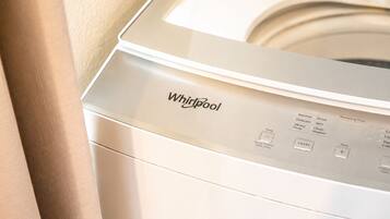 A front view of a Whirlpool washing machine with control panel and buttons.