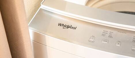 A front view of a Whirlpool washing machine with control panel and buttons.