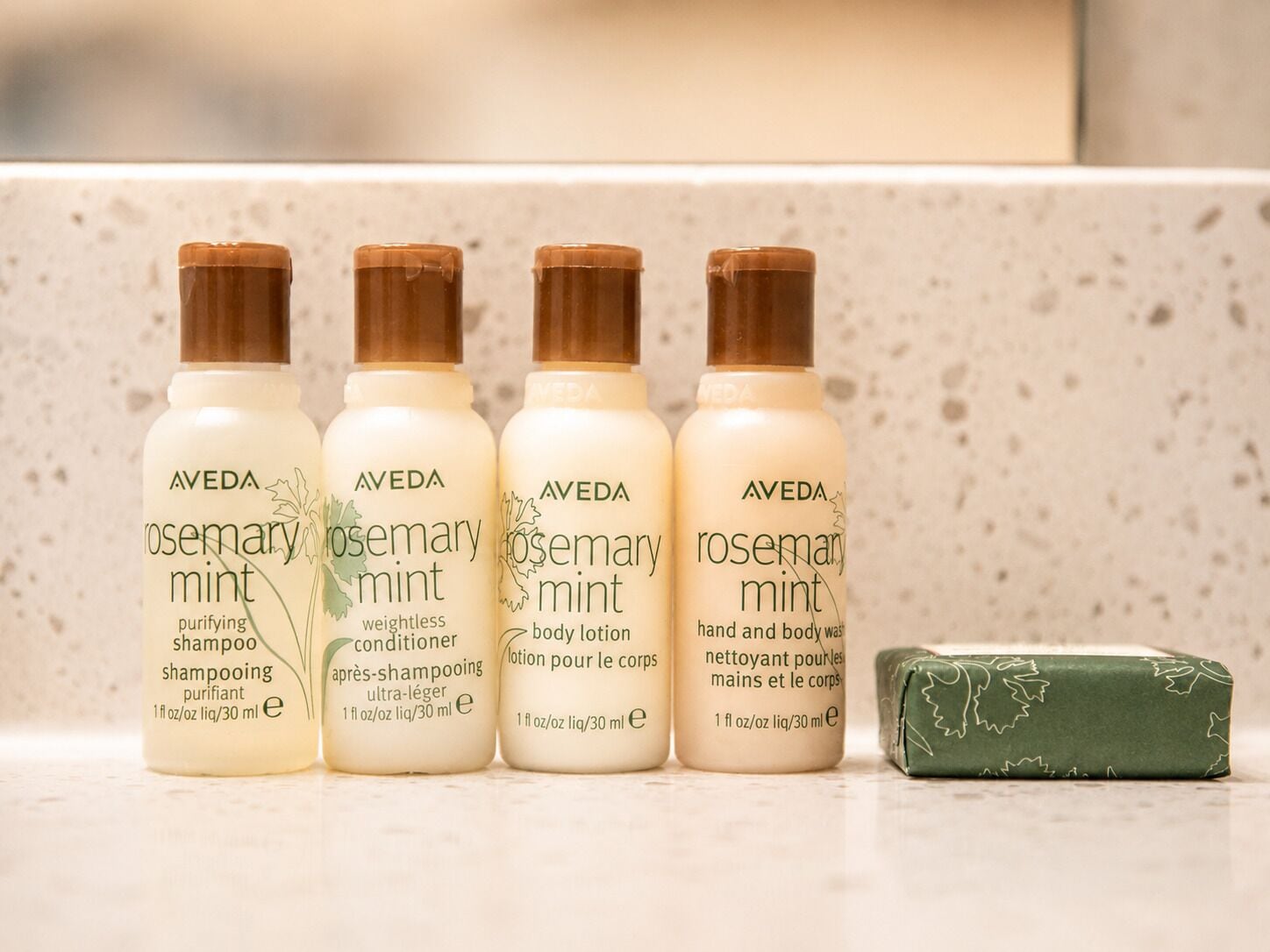 Four bottles of Aveda Rosemary Mint products and a bar of soap.