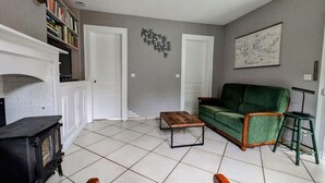 Un salon avec une cheminée, un canapé vert et une table basse.