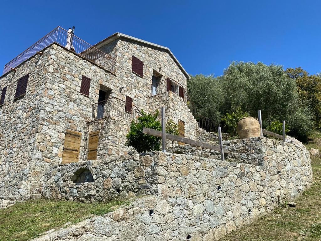 A stone building with multiple windows and a balcony.