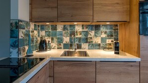 A kitchen with wooden cabinets, a tiled backsplash, a stainless steel sink, and a coffee maker. - 4-guest Bungalow Near Texel Dunes (De Koog)