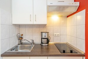 Eine Küche mit Spüle, Kaffeemaschine und Herd.