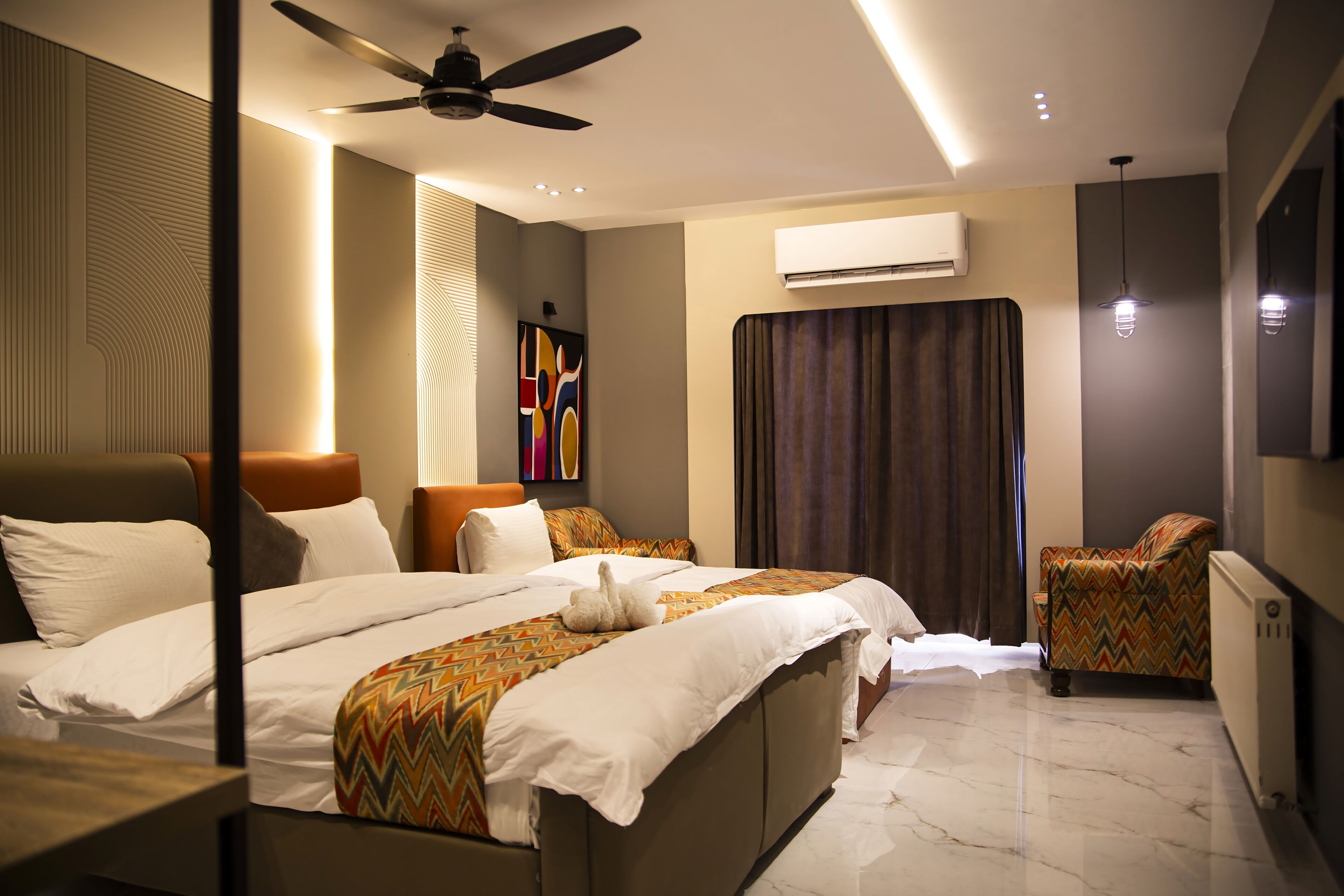 Hotelkamer met een groot bed, een plafondventilator, een airconditioning en uitzicht op buiten.