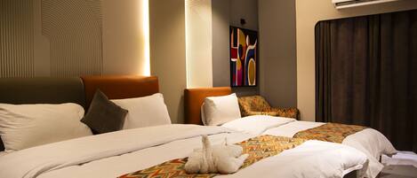 A hotel room with two beds, a large wall art piece, and an air conditioning unit.