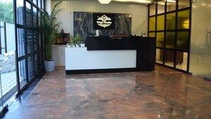 A reception desk with a sign reading 'King's Paradise,' a potted plant, and a chandelier.