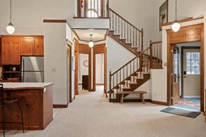 A spacious kitchen with wooden cabinets and a stainless steel refrigerator. - Tremblant Prestige - Manoir 112-10 (Mont-Tremblant)
