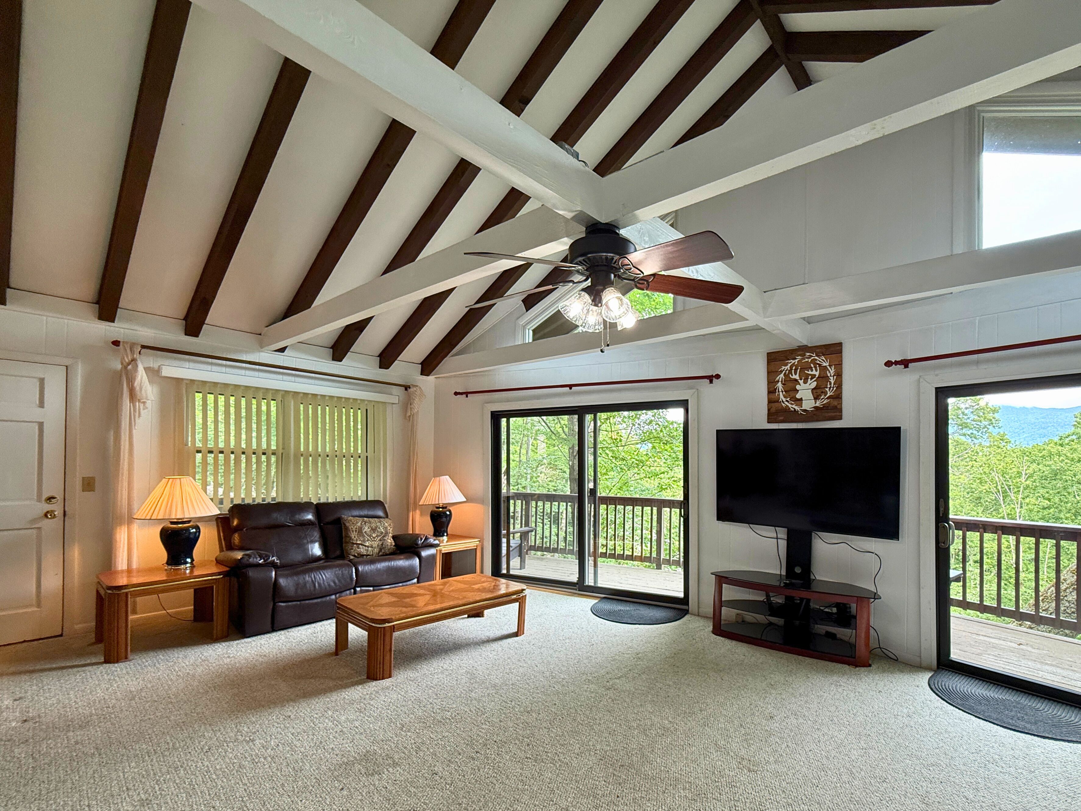 A living room with a ceiling fan, a TV, a sofa, and a coffee table.
