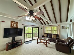 A living room with a ceiling fan, a TV, a sofa, and a coffee table. - six-bedroom, four-bathroom home comfortably accommodates up to 17 guests (Sugar Mountain)