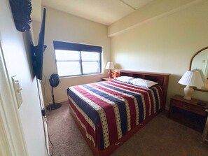 A bedroom with a bed, a window, a fan, and a nightstand with lamps. - Escape to the cool mountain air and breathtaking views (Sugar Mountain)