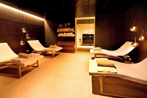 A modern spa with reclining chairs, a reception area, and a shelf with towels. - Casa Palma (Muralto)