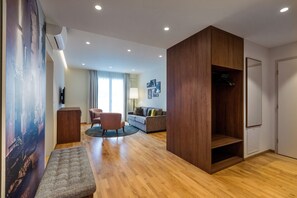 A modern living room with a wooden floor, a grey sofa, a round coffee table, and a wooden cabinet. - Casa Palma (Muralto)
