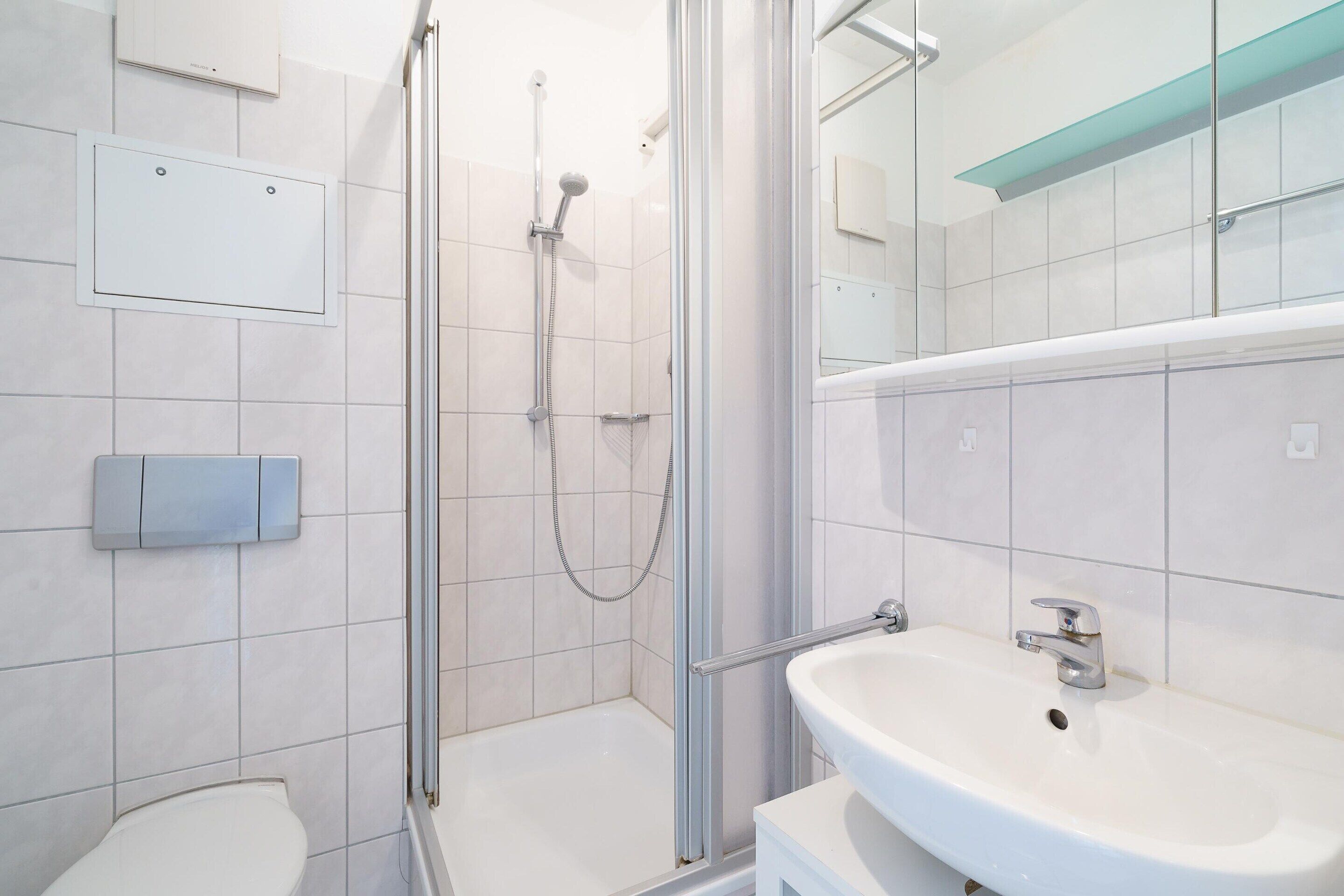 Un baño moderno con ducha, inodoro y lavamanos.