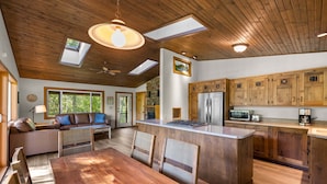 A spacious kitchen with wooden cabinets, a central island, and skylights. - Private Sampson Lake frontage home - Bordering Whitefish City Limits (Whitefish)