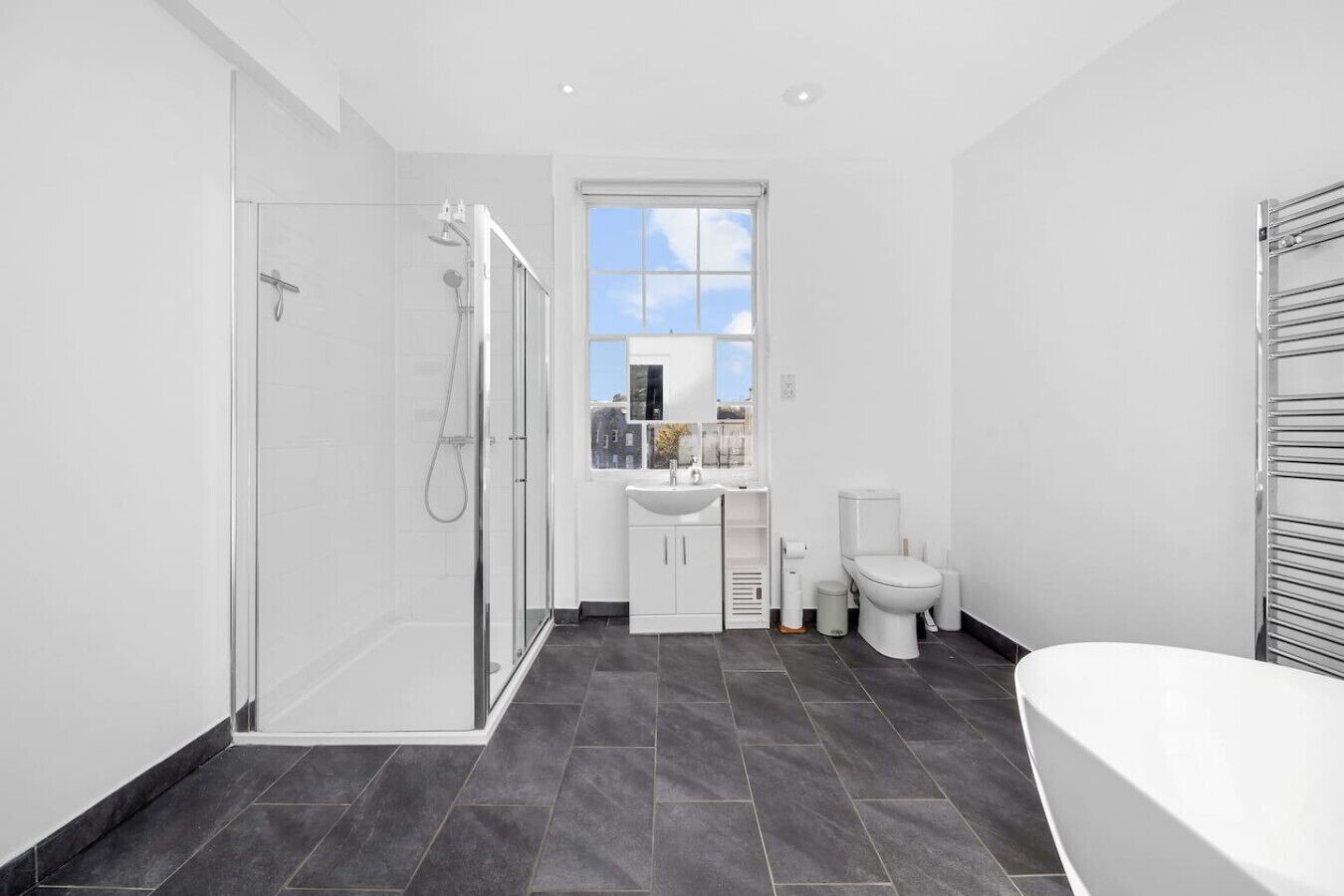 Un baño moderno con ducha, inodoro, lavabo y bañera.