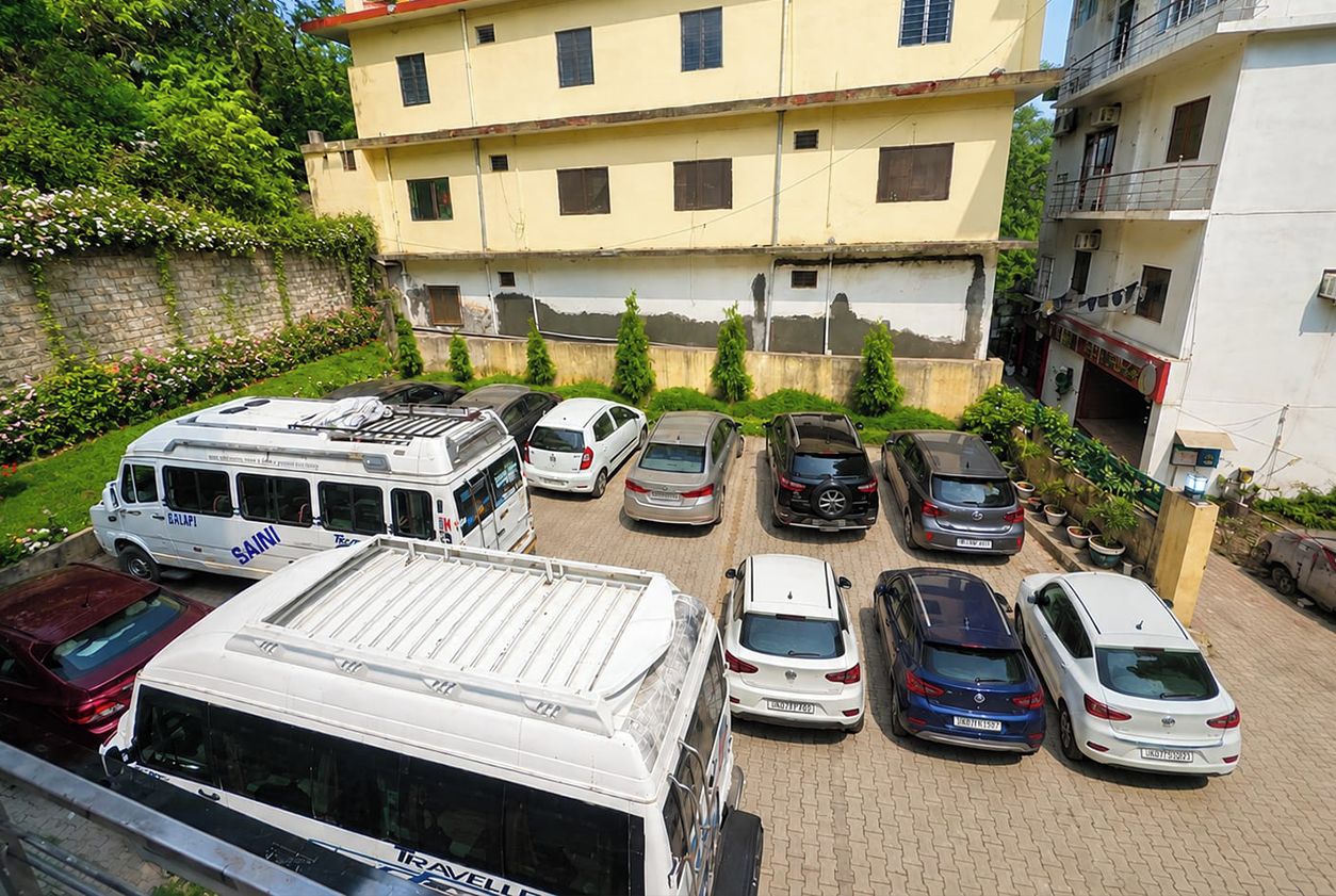 A multi-story building with a parking lot in front.