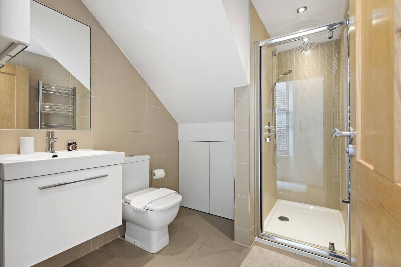 A modern bathroom with a shower, toilet, and sink.