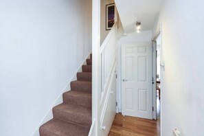 A staircase with carpeted steps leading to a white door. - Double Ensuite 2 Min To Tube (Greater London)