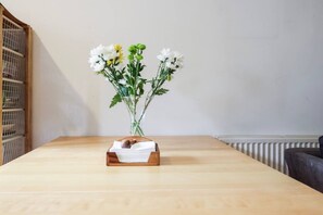 A wooden table with a vase of flowers and a wooden box with papers. - Double Ensuite 2 Min To Tube (Greater London)