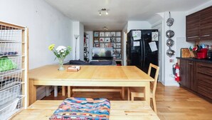 Eine kleine Küche mit Esstisch, Fernseher und Kühlschrank.