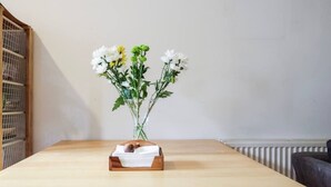 Ein Holztisch mit einem Blumenstrauß und einer Holzkiste mit Papieren.