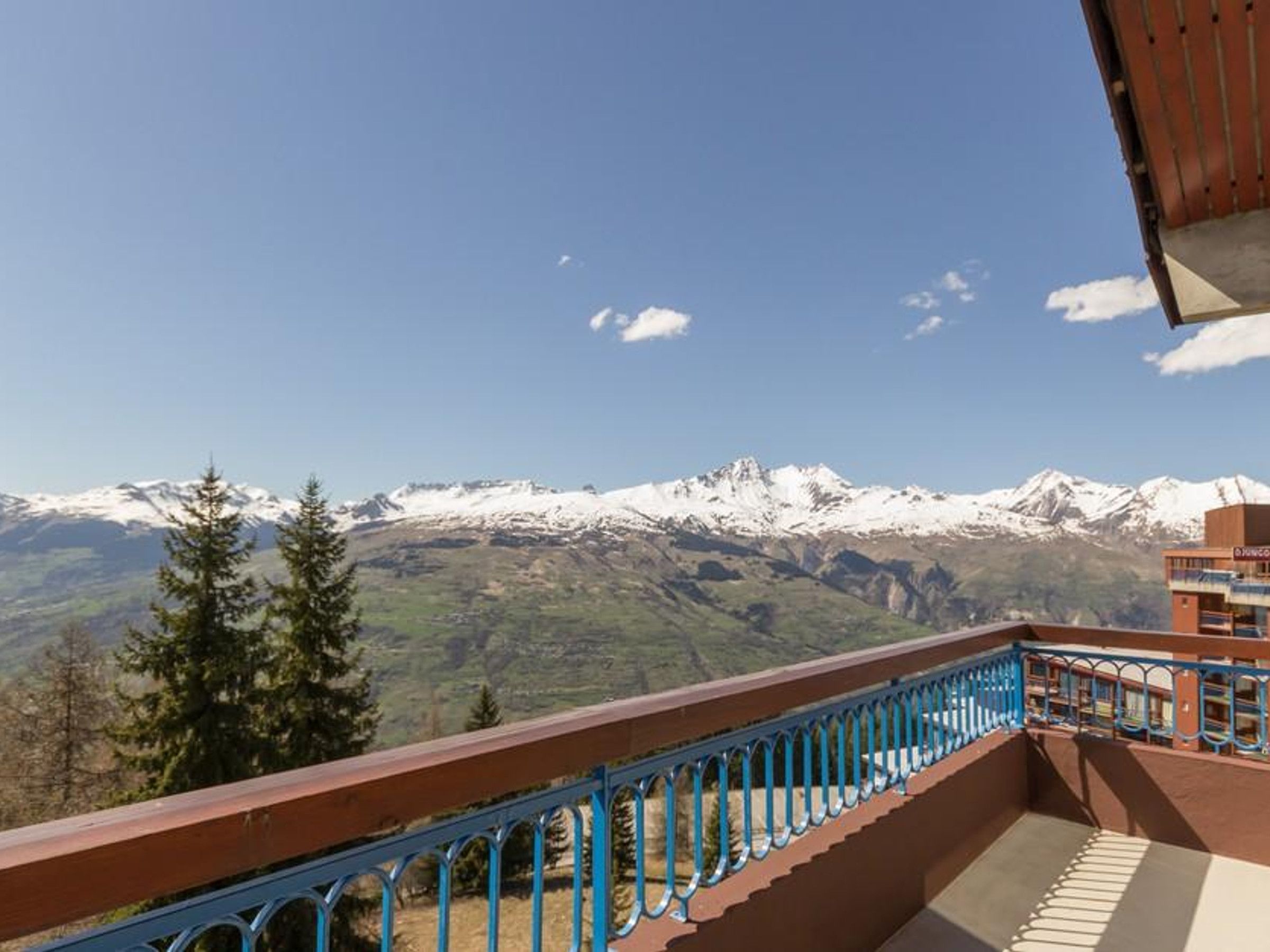 Ein Balkon mit Blick auf schneebedeckte Berge und einen klaren Himmel.