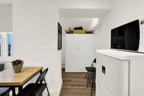 Eine moderne Küche mit integriertem Mikrowellenherd, einem Holzespeisetisch und einer kleinen Sitzecke.