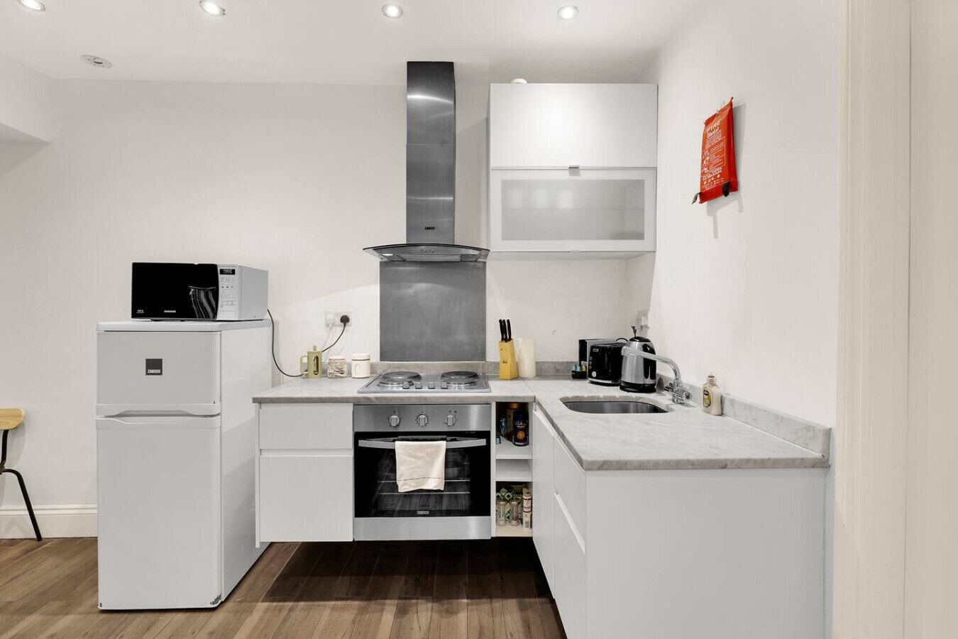A modern kitchen with a built-in oven, a stove, and a microwave.