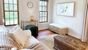 Ein gemütliches Zimmer mit einem großen Bett, einer Holzbank und einem kleinen Tisch mit einer Lampe.