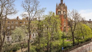 A historic building with a prominent tower, surrounded by trees and other buildings. - 1BR in Prime Islington Location near Angel Station (Greater London)