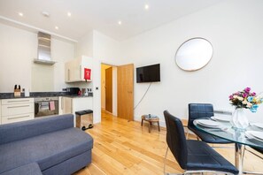 Eine moderne Wohnung mit Küche, Essbereich und Wohnzimmer.